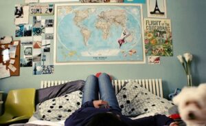 Una chica en su habitación mirando mapa del mundo