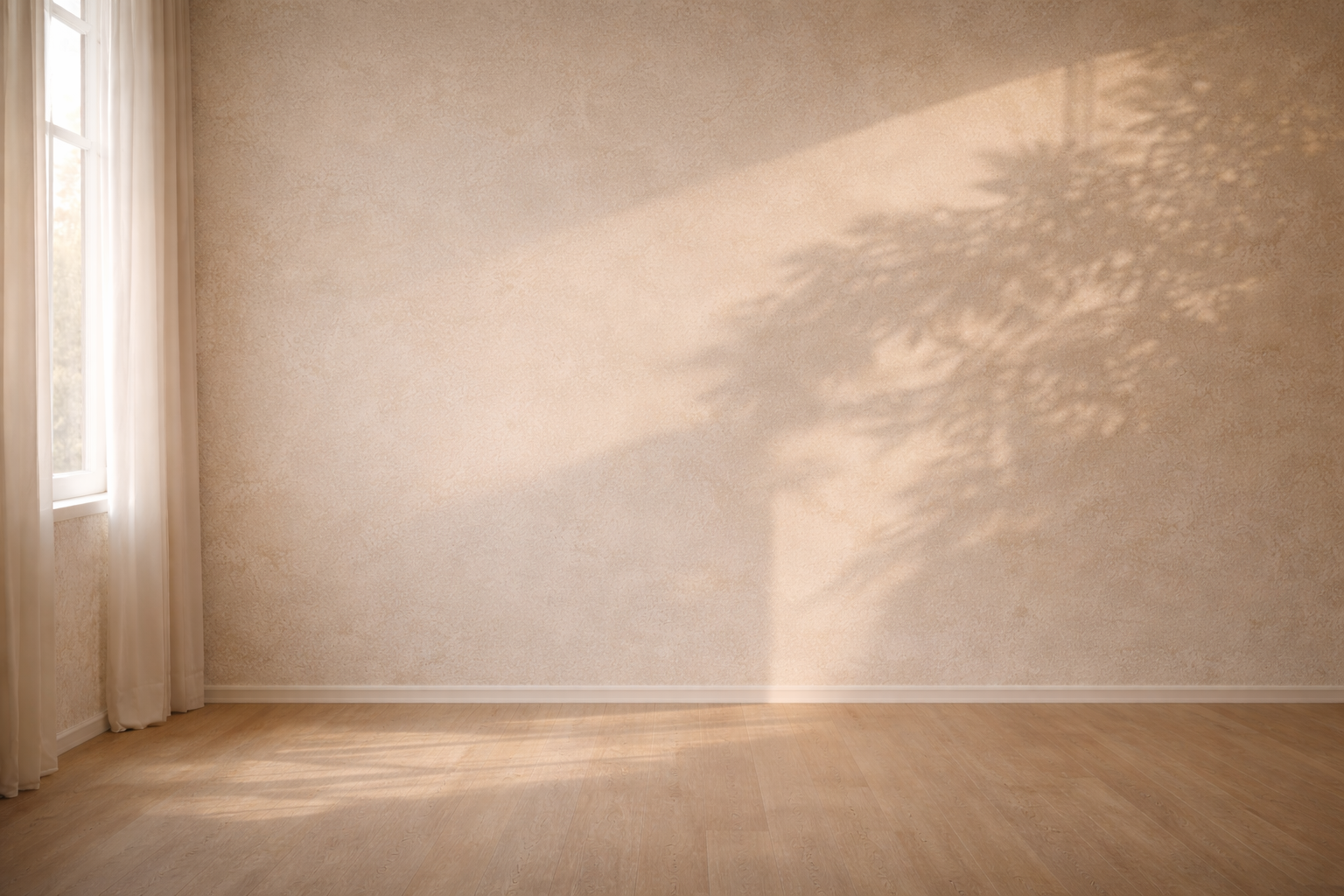 Pared beige con sombra vegetal que divide suavemente el espacio en dos zonas de luz.