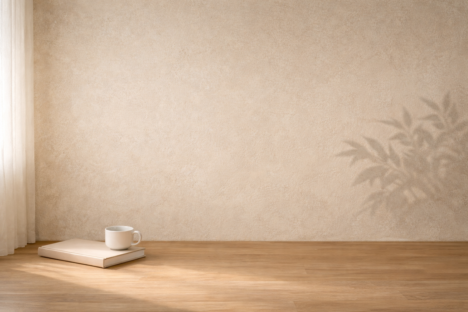 Interior minimalista con pared beige iluminada por luz natural, un libro cerrado y una taza blanca sobre suelo de madera en un ambiente tranquilo de reflexión.